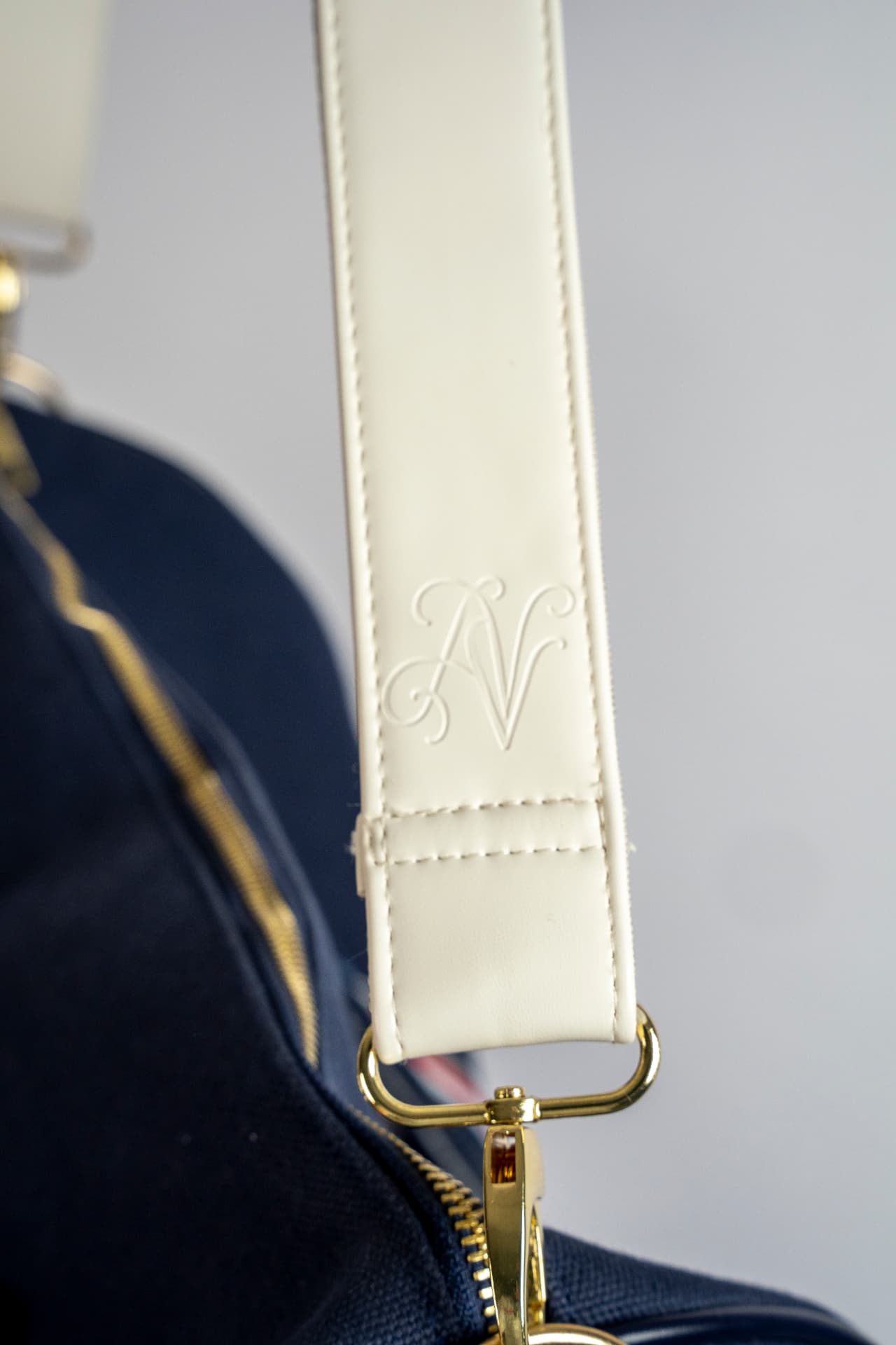 Nærbilde av skulderstroppen med preget AURÉVONE-monogram